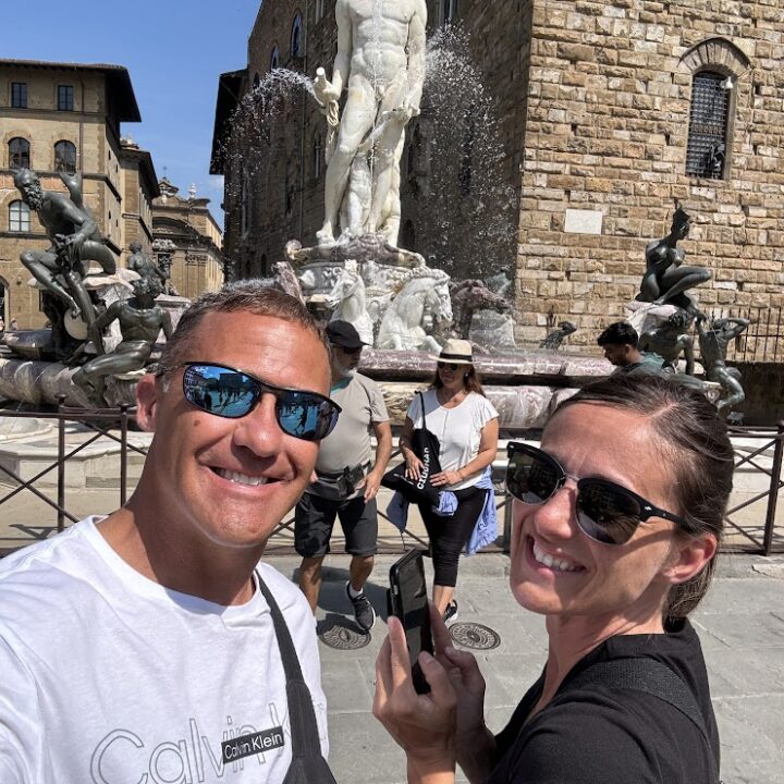 Paul and corene Hutchings taking a selfie in front of a statue of David in Italy