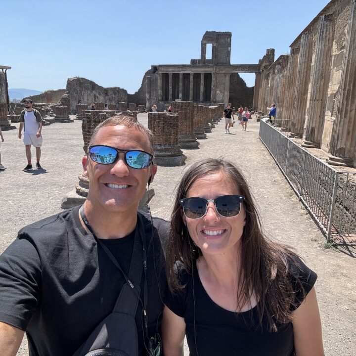 Paul and corene Hutchings taking a selfie in front of a ruins in Pompeii